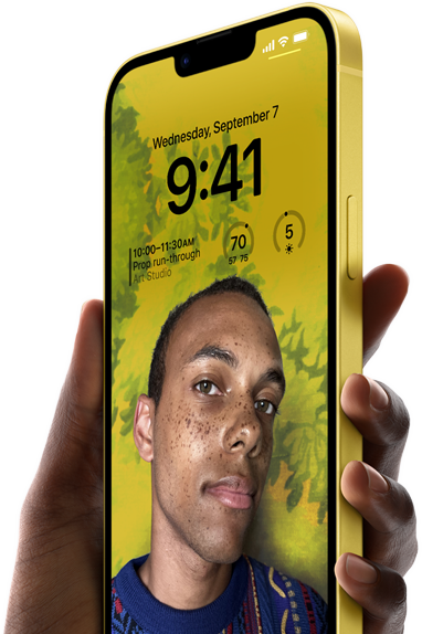 Χέρι που κρατά ένα iPhone 14 Plus σε κίτρινο χρώμα, το οποίο εμφανίζει μια εξατομικευμένη Οθόνη Κλειδώματος.